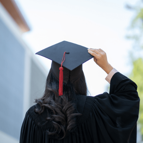 female with dark hair in graduation cap and gown